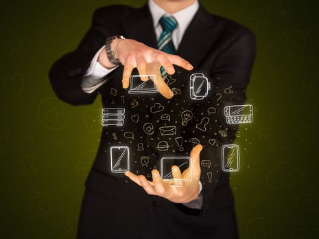 Businessman holding icons related to devices and communication